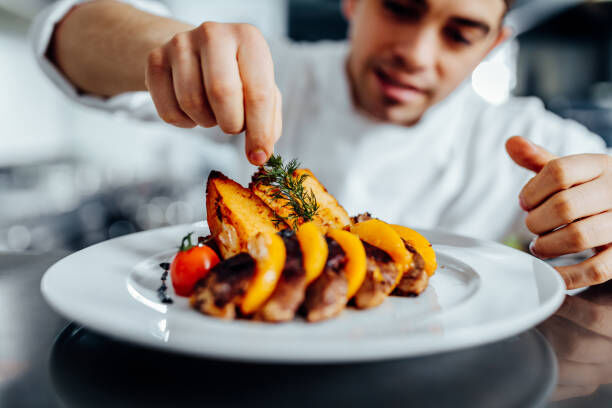 Shot of a young chef decorating meal in the kitchen